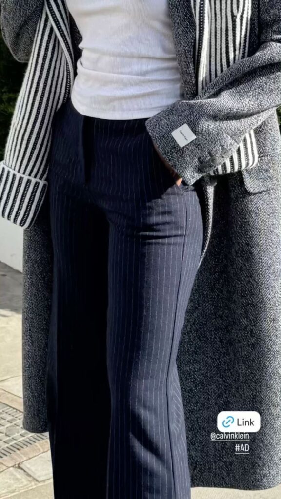 Lady putting on navy strip corporate pants in the winter