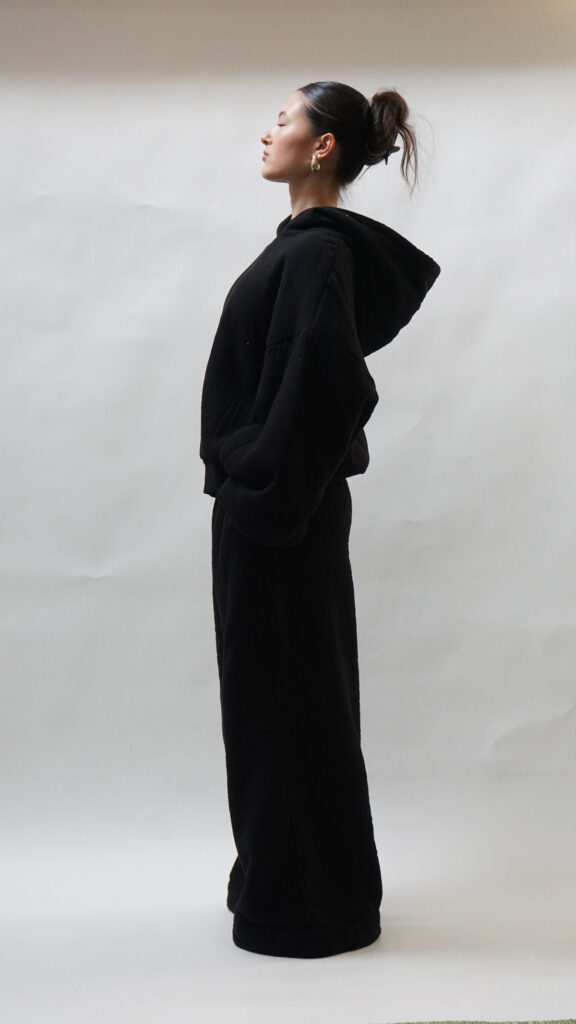 Lady putting on classy black sweats with the pants