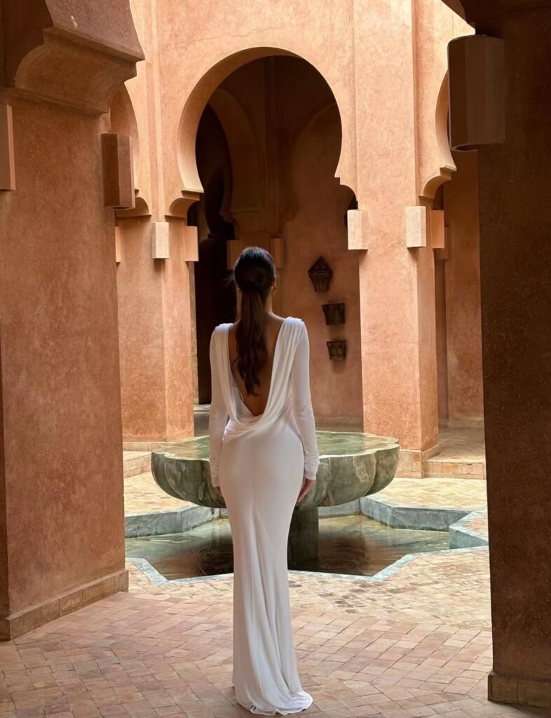 Classy woman putting on a backless white dress