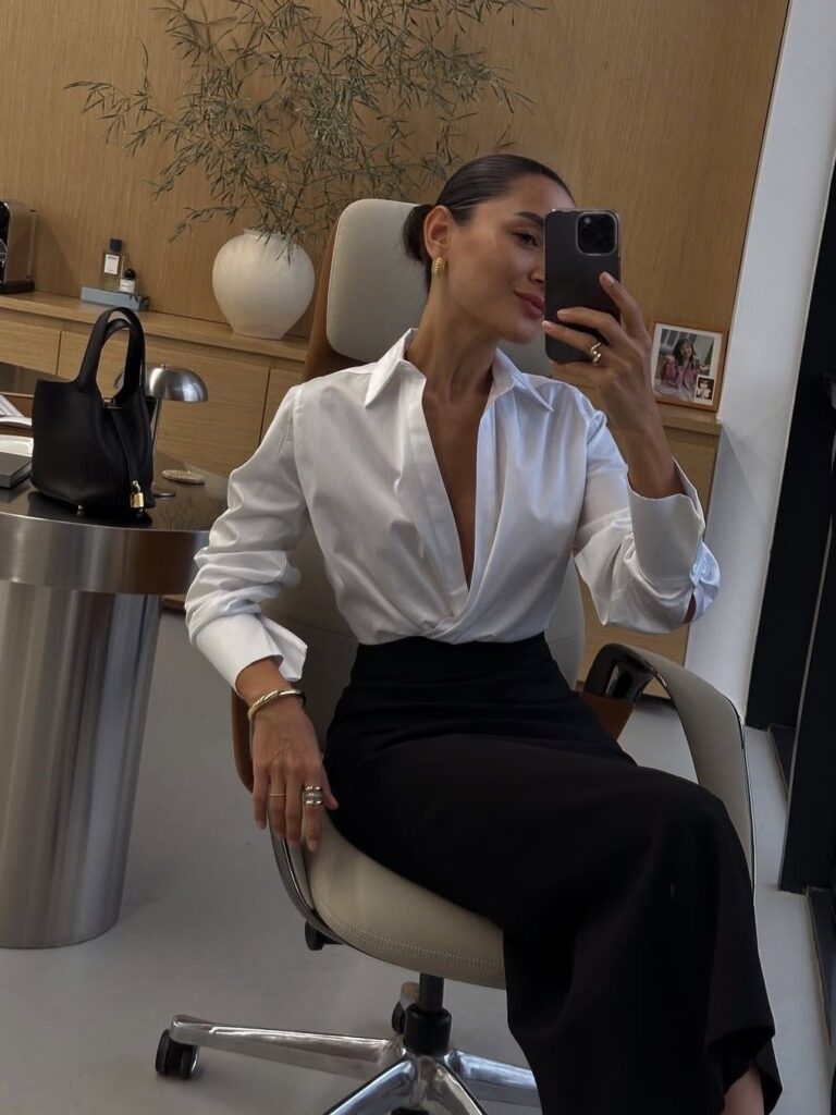 Lady puttin on black pencil skirt with a white bottom up shirt 