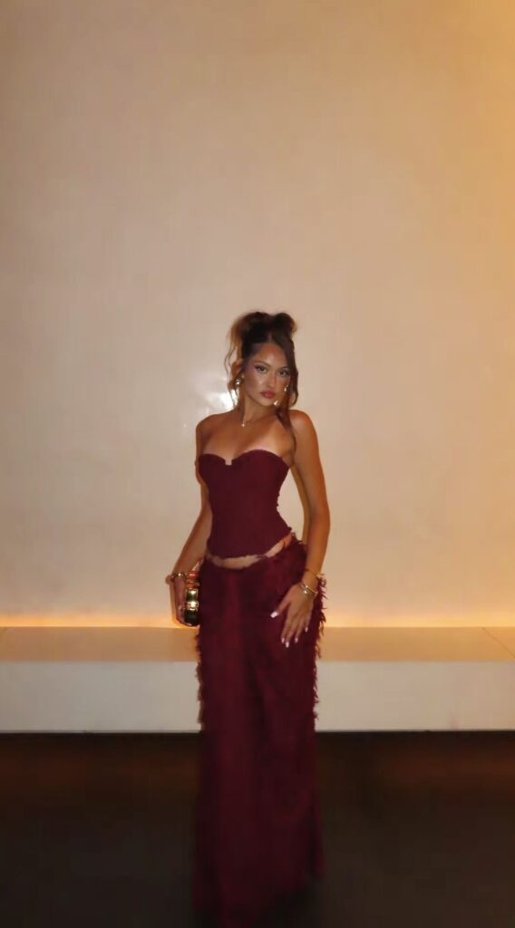 13 Classy Birthday Dinner Outfit Ideas for Women (Elegant & Feminine Looks) Lady putting on a chic birthday burgundy outfit