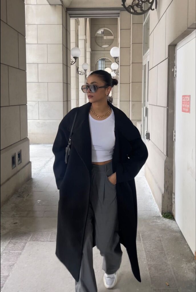 Lady putting on a casual outfit with a trench coat 