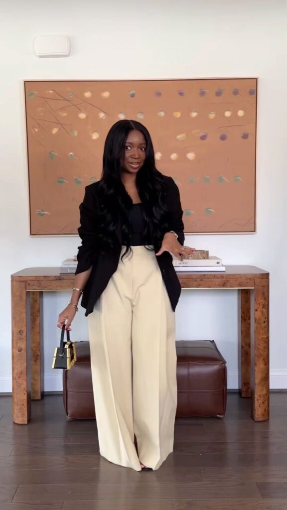Chic lady putting on a black blazer and brown corporate pants 