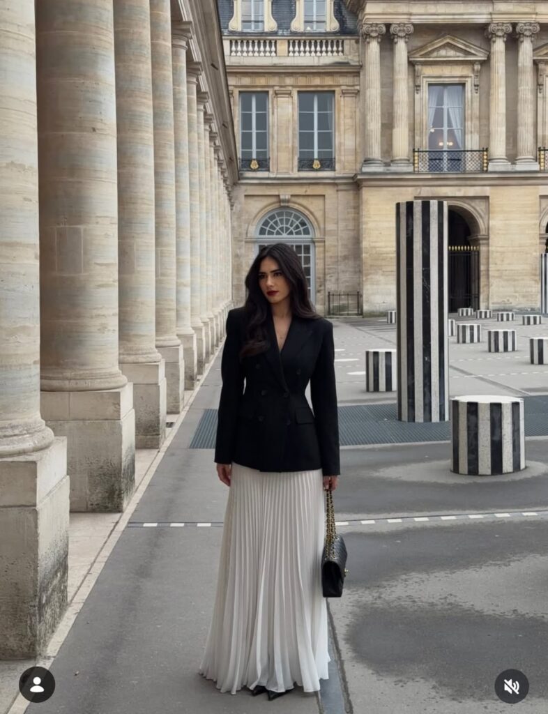 Classy lady putting on a blazer outfit with a plated white skirt